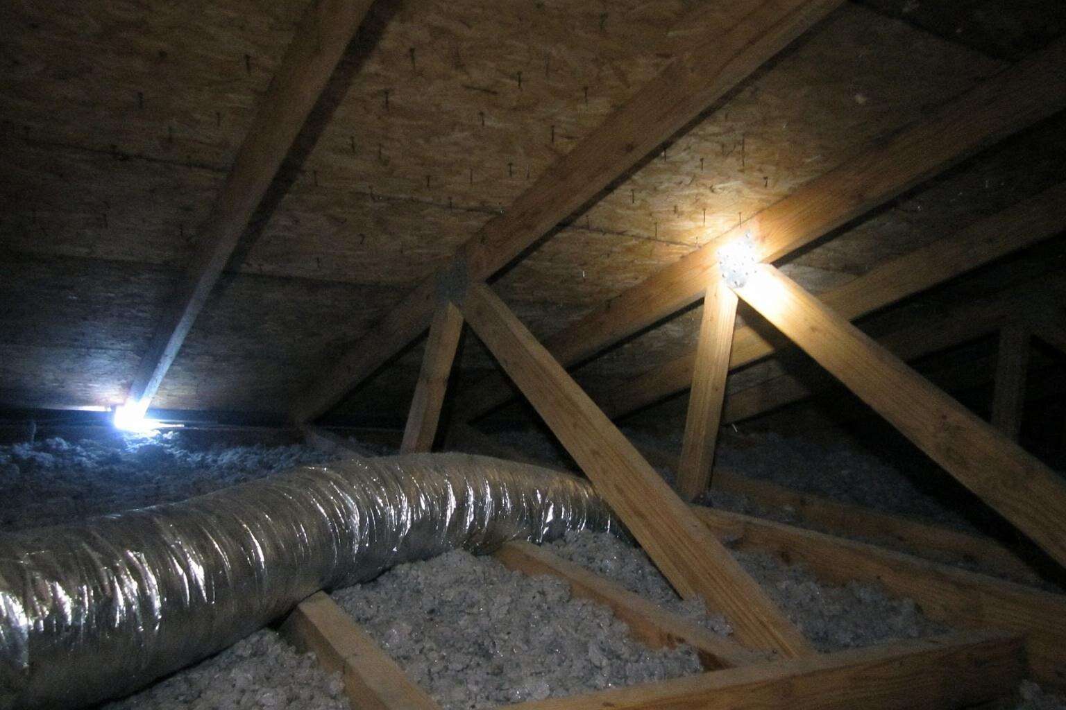 Rafters and roof decking inside a dim vented attic