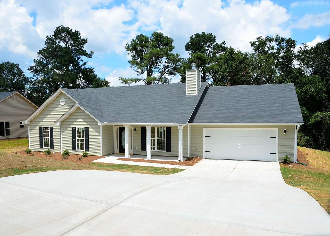 A newly built house with tall pines standing behind it